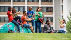 Photo of students standing, sitting and talking outside of Bohn Hall