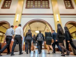 Students walking in school of business entryway