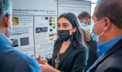 Student explaining posterboard content to visiting academics