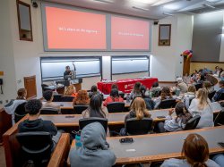 Wamwari in front of room full of students in lecture hall