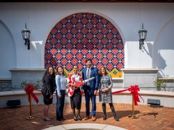 Five people standing in front of ribbon before cutting