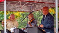 Direct Latin Influence band members with instruments under tent
