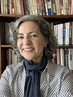 photo of professor Nancy Carnevale standing in front of a full bookshelf