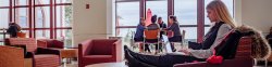 Student using laptop in university hall lounge