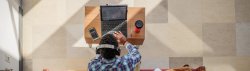 Top view of a student working on a laptop with headphones
