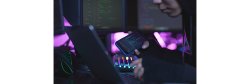photo of unrecognizable cyber hacker wearing hood while working on programming in dark room, copy space