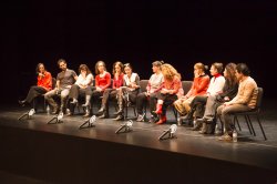 Image from Le Sorelle Macaluso event with a group people lined up on stage sitting in chairs.