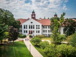 Wide shot of the College Hall building on campus in the summer.