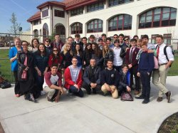 Image of a large group of students and faculty standing in a group standing outside of Conrad Schmitt Hall.