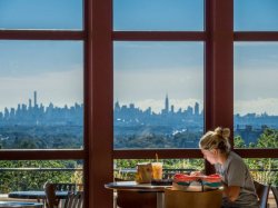Student reading in CELS overlooking NYC Skyline