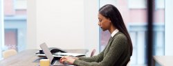 African American woman Working On Laptop At Desk In Meeting Room