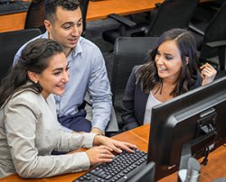 2 female and one male student working as a group
