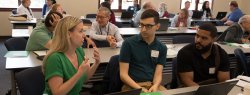 A woman enthusiastically converses with other participants at a conference
