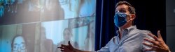 white male faculty teaching in front of projected zoom class