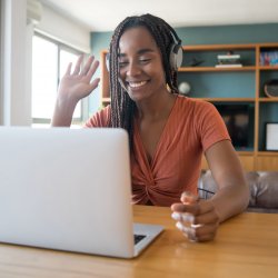 african american Woman working from home. waving to laptop