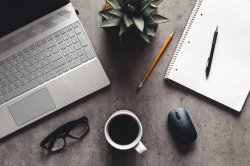 laptop and book, coffee on gray background, Top view of office desk on textured gray background