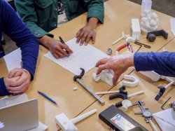 Top-down photo of a professor performing a demonstration of tools.