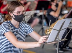 student setting up her music stand and arranging sheet music