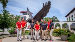 Photo of MS in Athletic Training students standing in front of Rocky statue on campus.