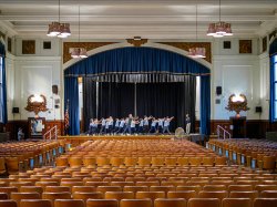 students rehearsing on stage in a theater