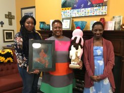 Chancellor Evans poses with alumni and art work