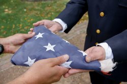 close-up of folded american flag being handed off in retirement ceremony