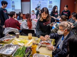 "Helpers show participants how to make kimchi"