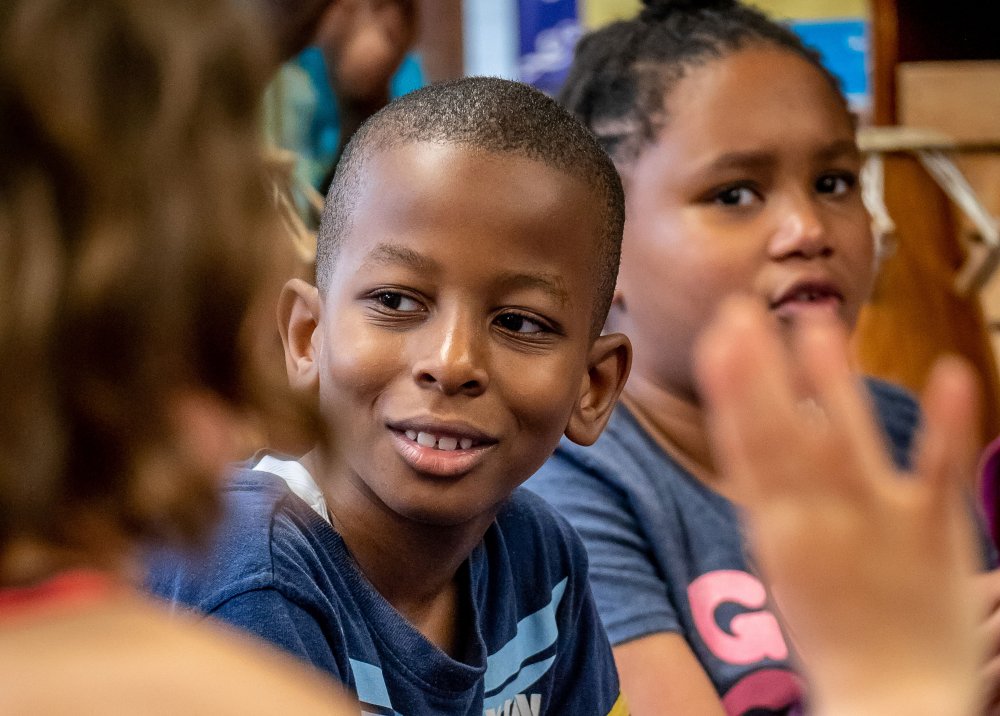 Elementary school students listening to teacher in classroom
