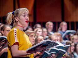 female vocalist in front of choir
