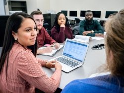 Students having meeting around a laptop.