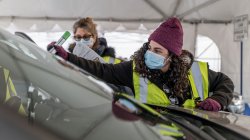 worker places sticker on vehicle's windshield