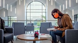 student working on homework in the new atrium after completion