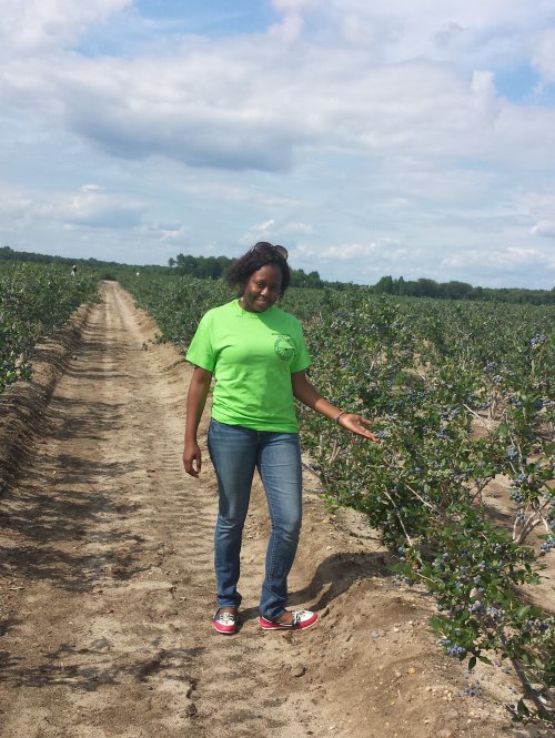 Guerline Pierre ’11 in blueberry field.