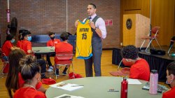 Speaker standing in front of a group of HSCI students