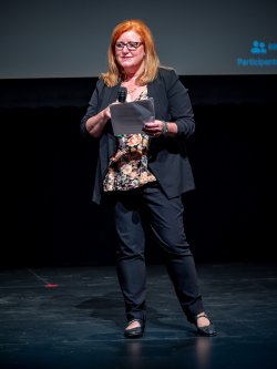 Amy Tuiniga on stage with microphone