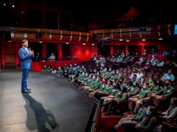 President Koppell on stage in Kasser Theater speaking to an audience full of Green Teams participants