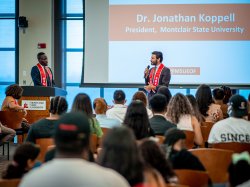 Dr. Koppell standing in front of crowd speaking into portable microphone