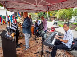 Direct Latin Influence band members with instruments under tent