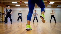 4 students facing instructor in dance studio