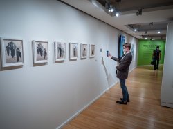 A visitor scans a QR code at the Tech/Know/Future exhibit