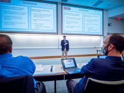 Fred Nagle speaking in front of presentation screens