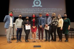 Photo of members of the FirstGen Initiatives Planning Committee at Montclair State in front of a stage