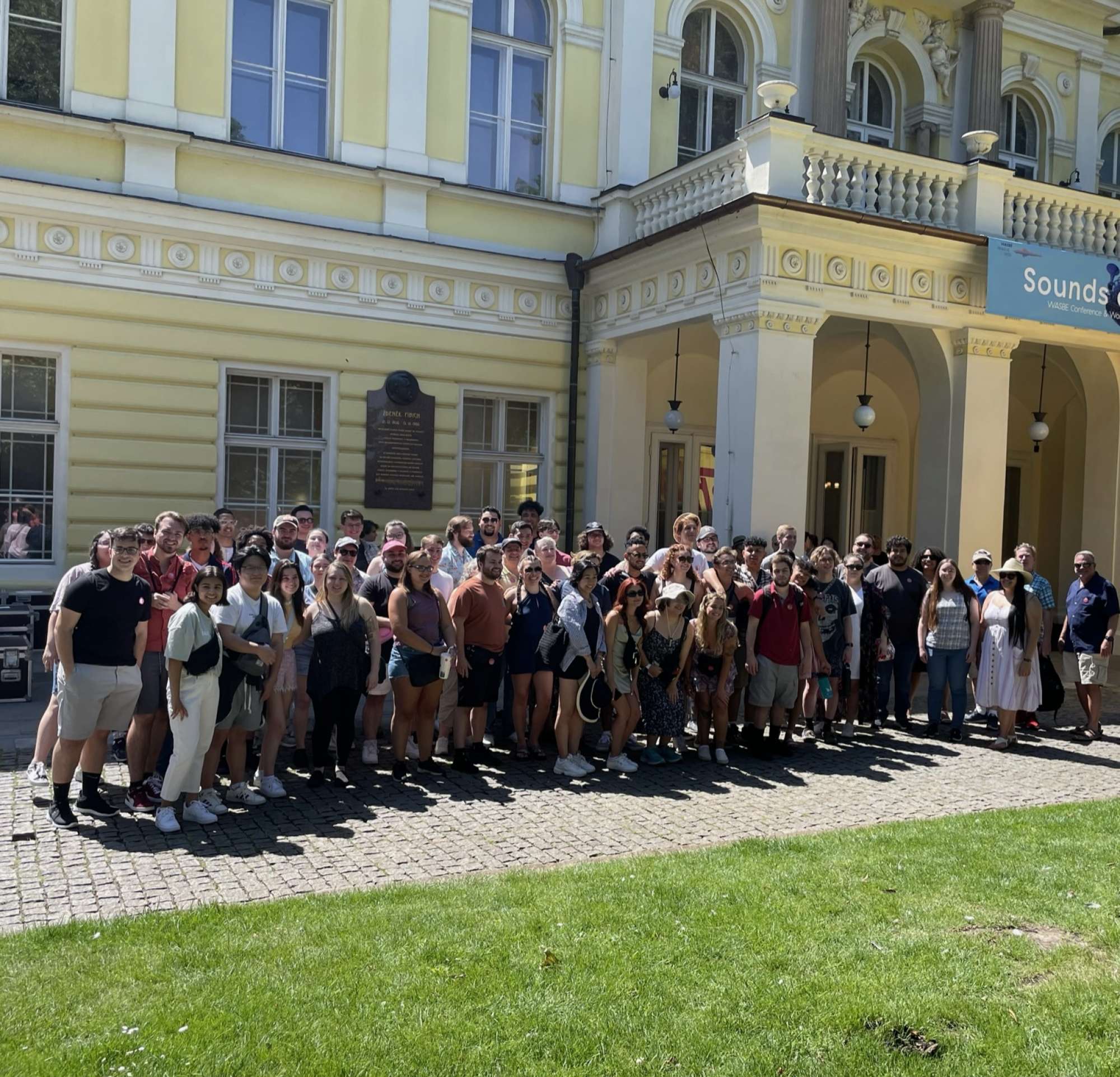 group of musicians pose outside the palace
