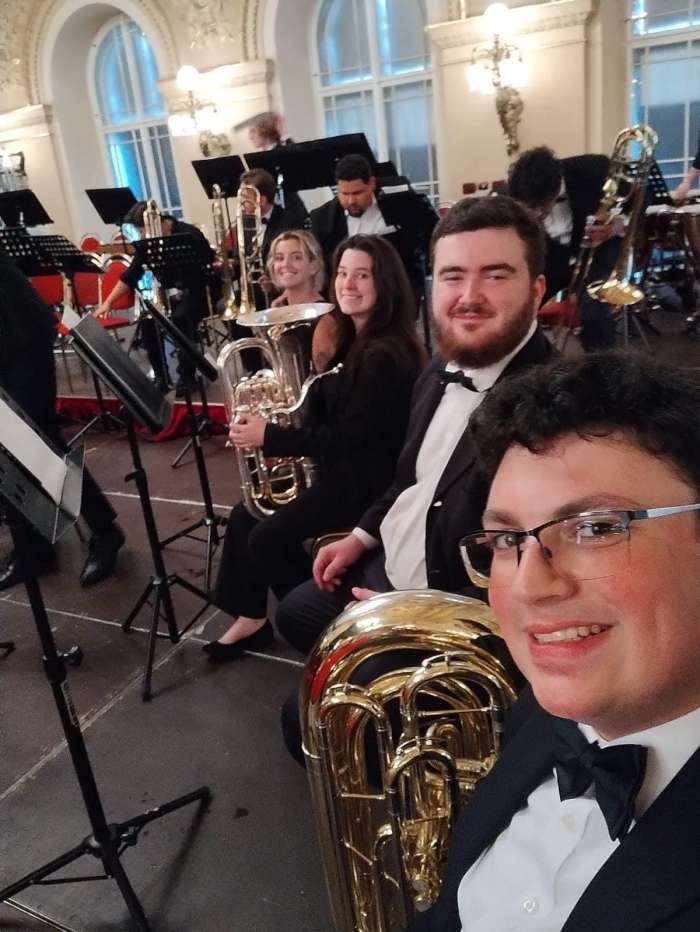musicians pose with their instruments on stage