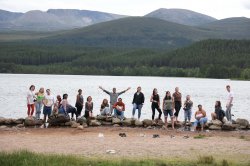 group of students pose in front of a river