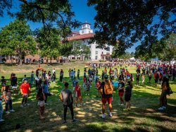 students gathered in groups on campus lawn