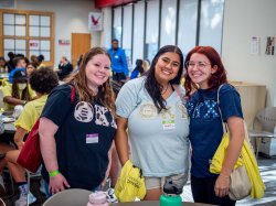 Three students smile for the camera