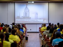 photo of attendees seated before a screen showing a video about September 11, 2001