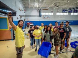 President Koppell holding his cell phone up to take a photo with students