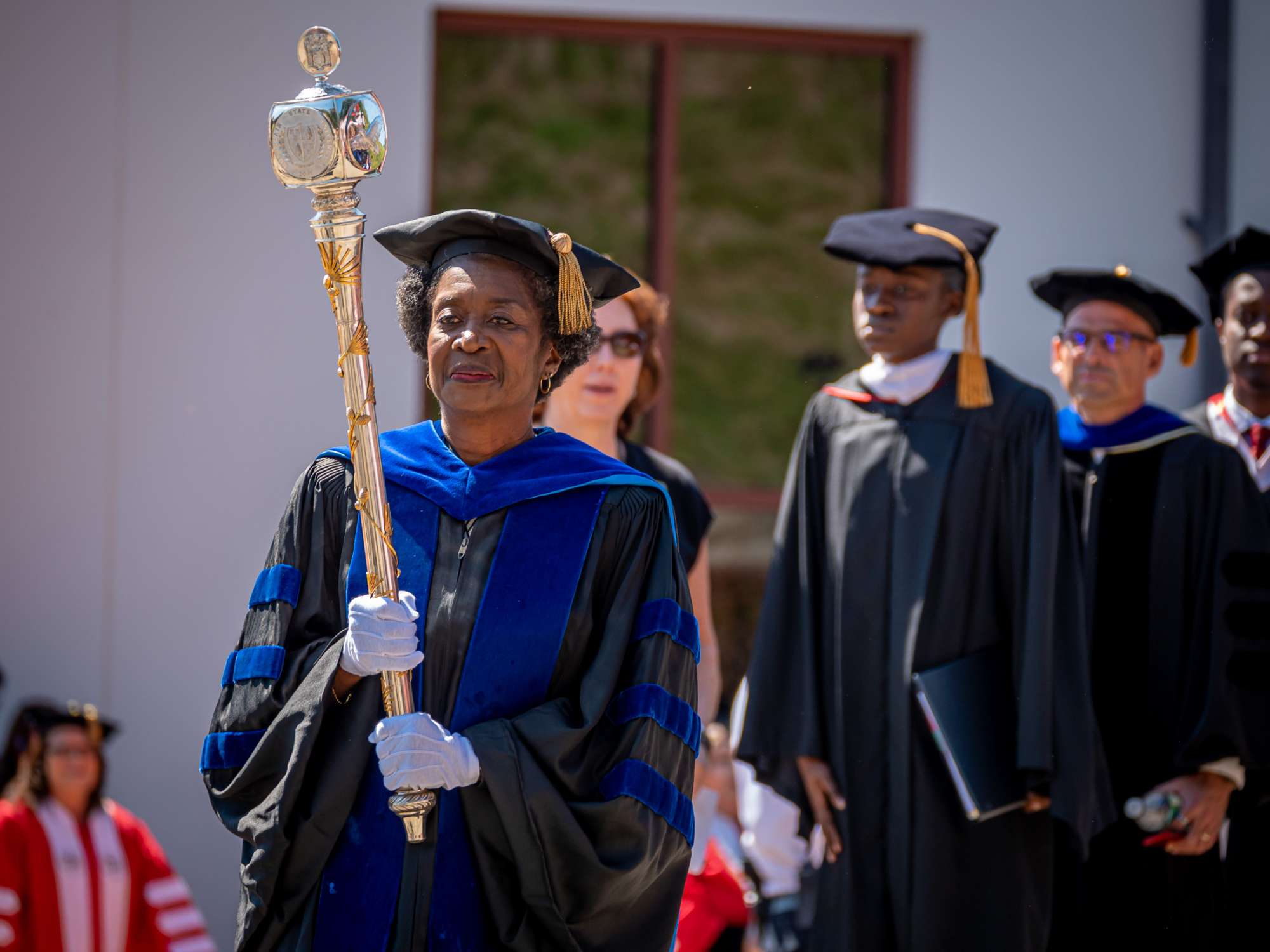 Sandra Adams leads the procession holding the University mace